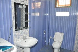 niebieska łazienka z toaletą i umywalką w obiekcie Relax Guest House w mieście Batapola