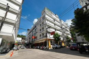 a large white building on a city street at One World One Home Patong 2 in Patong Beach