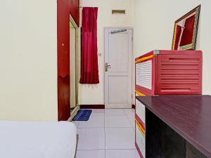 een kamer met een rode dressoir en een rood gordijn bij OYO Life 92546 Kost Merah Bojongsoang Syariah in Bandung