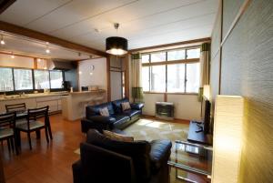 a living room with a couch and a dining room at Hakuba Forest House in Hakuba