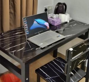 einen Laptop auf einem Tisch in der Unterkunft PD ROOM STAY in Port Dickson