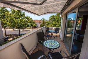 a balcony with tables and chairs and a view of a street at Apartments Gardelin Superior in Zadar