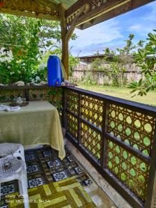 einen Tisch auf einem Balkon mit einem Zaun in der Unterkunft Shirley's Cottage - Pamilacan Island in Baclayon