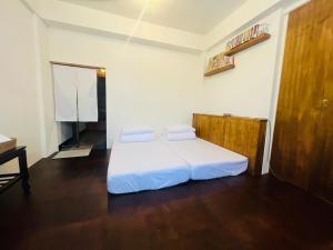 1 dormitorio con 1 cama con 2 almohadas en 白紙寓所blank slate B&B-鄰近夜市四人包棟, en Luodong