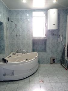 a white tub in a bathroom with a window at Sun city hostel in Yerevan