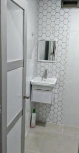 Baño blanco con lavabo y espejo en PD ROOM STAY en Port Dickson