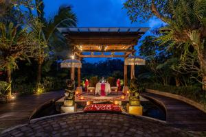 a dining area at a resort at night at Nau Villa Ubud in Tegalalang