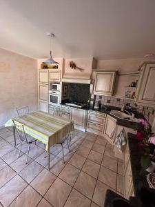 uma cozinha com uma mesa e cadeiras em Chambres des arrys em Bas-en-Basset