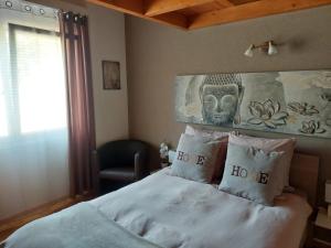 a bedroom with a bed with pillows with the words be home at Les balcons du Rhône in Daillon