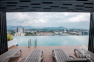 uma varanda com cadeiras e vista para a água em Ipoh Horizon Infinity Pool Suites by Verve em Ipoh