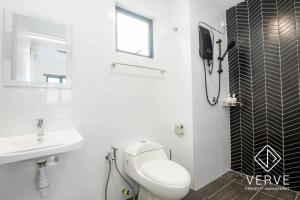 a white bathroom with a toilet and a sink at Ipoh Horizon Infinity Pool Suites by Verve in Ipoh