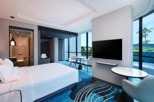 a hotel room with a bed and a flat screen tv at Novotel Yogyakarta International Airport Kulon Progo in Yogyakarta