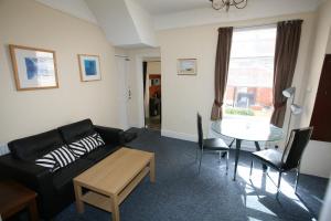 a living room with a black couch and a table at Flat 1 in Teignmouth