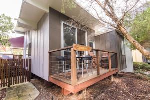 Una casa con una terraza con dos taburetes. en Allure Stradbroke Resort, en Point Lookout