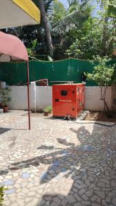 a red appliance sitting on a patio next to a fence at Paradise corner in Puducherry
