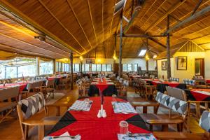a restaurant with tables and chairs with red tablecloths at Sentrim Mara Lodge in Ololaimutiek