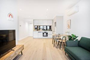 een woonkamer met een bank en een tafel bij Gorgeous 1B Docklands apt/Amazing view facility #MQ1312 in Melbourne