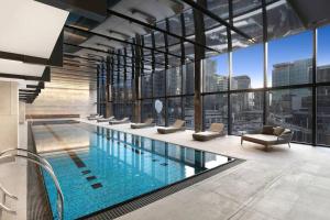 een zwembad in een gebouw met uitzicht op de stad bij Gorgeous 1B Docklands apt/Amazing view facility #MQ1312 in Melbourne