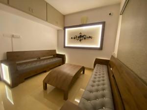 - un salon avec un canapé et un banc dans l'établissement La Tamara Luxury, à Pondichéry
