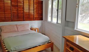 1 dormitorio pequeño con 1 cama y 2 ventanas en Wolvi Wonderland - Eco Escape, en Wolvi