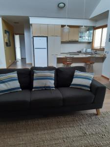 a black couch with two pillows in a living room at The Lakes Apartments in Lakes Entrance