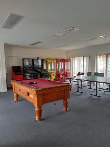 a ping pong table in a room with several tables at The Lakes Apartments in Lakes Entrance