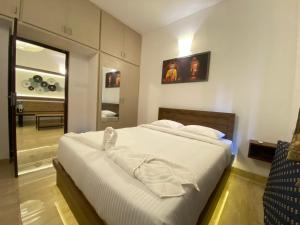 ein Schlafzimmer mit einem großen Bett mit weißer Bettwäsche in der Unterkunft La Tamara Luxury in Puducherry