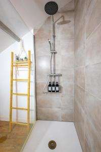 La salle de bains est pourvue d'une douche avec une échelle et une étagère. dans l'établissement The Savannah House Marmande centre, à Marmande