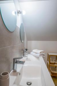 La salle de bains est pourvue d'un lavabo blanc et d'un miroir. dans l'établissement The Savannah House Marmande centre, à Marmande