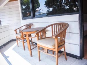 two chairs and a wooden table on a porch at Hotel Sukamulya Pasteur in Bandung