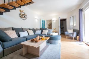 uma sala de estar com um sofá azul e uma mesa em The Savannah House Marmande centre em Marmande