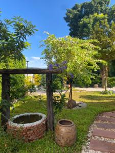 a garden with a barrel and a tree in the grass at Rivera 105 Vacation Home in Kathun