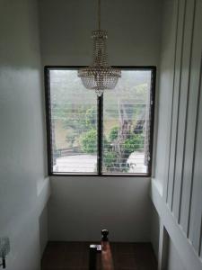 ein großes Fenster in einem Zimmer mit einem Kronleuchter in der Unterkunft Rivera 105 Vacation Home in Kathun