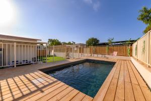 una piscina con terraza de madera y una piscina en דירת נופש מרחבים Merhavim Villa en Shadmot Devora