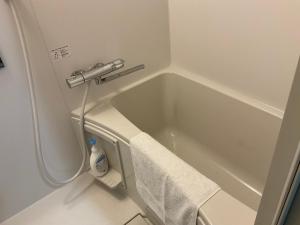 a bathroom with a bath tub with a towel at Gallery Compass- Art Apartments Osaka with Breakfast Free Parking in Osaka +77 photos