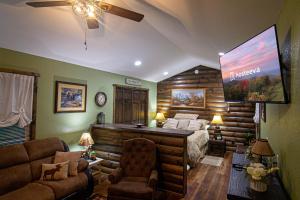 a bedroom in a log cabin with a bed and a flat screen tv at The Lil House in Robbinsville