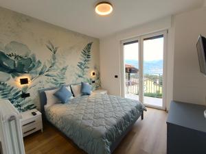 een slaapkamer met een bed en een groot raam bij Cà di Cambret with lake View in Stresa