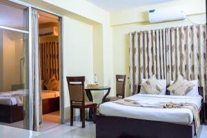 1 dormitorio con 2 camas y mesa con silla en Hotel Beach Park en Cox's Bazar