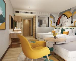 een woonkamer met een witte bank en een gele stoel bij M Social Hotel Phuket in Patong Beach
