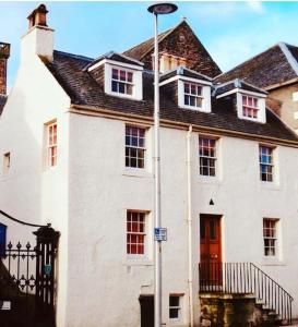 a large white house with a black roof at Jacobite's Retreat, 17th century cottage in the heart of Inverness in Inverness