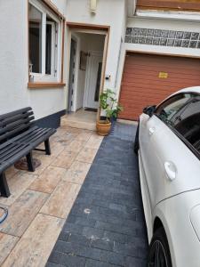 a white car parked in front of a house with a bench at Stilvoll und gemütlich in Bellheim