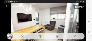 - un salon avec une table, une télévision et une chaise dans l'établissement apartament MT burszynowe osiedle, à Jantar