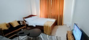 a bedroom with a bed and a couch and a tv at Premier Stays Ruiru in Ruiru