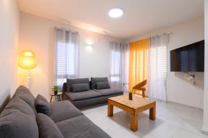 ein Wohnzimmer mit einem Sofa und einem Tisch in der Unterkunft דירת נופש מרחבים Merhavim Villa in Shadmot Devora
