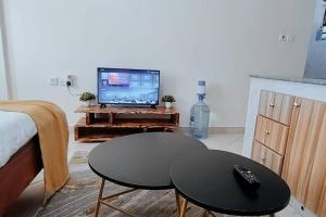 a living room with a table and a tv at Premier Stays Ruiru in Ruiru