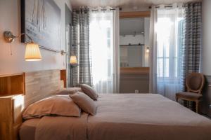 a bedroom with a large bed and a window at La Martinoise Patio in Saint-Martin-de-Ré