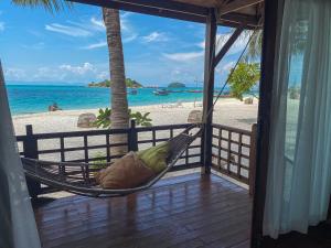a hammock on a porch overlooking the beach at Lipe Beach Resort in Ko Lipe