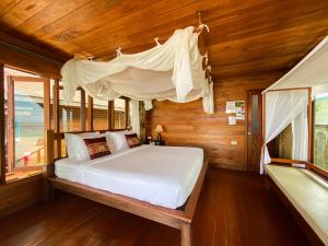 a bedroom with a bed with a canopy at Lipe Beach Resort in Ko Lipe