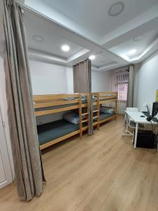 a room with two bunk beds and a desk at Hostel Inn Downtown in Belgrade
