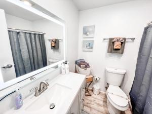 a bathroom with a sink and a toilet and a mirror at Gaslamp 2bdrm - W Parking & 4 Beds #304 in San Diego